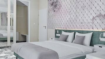 Un dormitorio moderno con una cama grande, un cabecero verde y una pared con estampado.