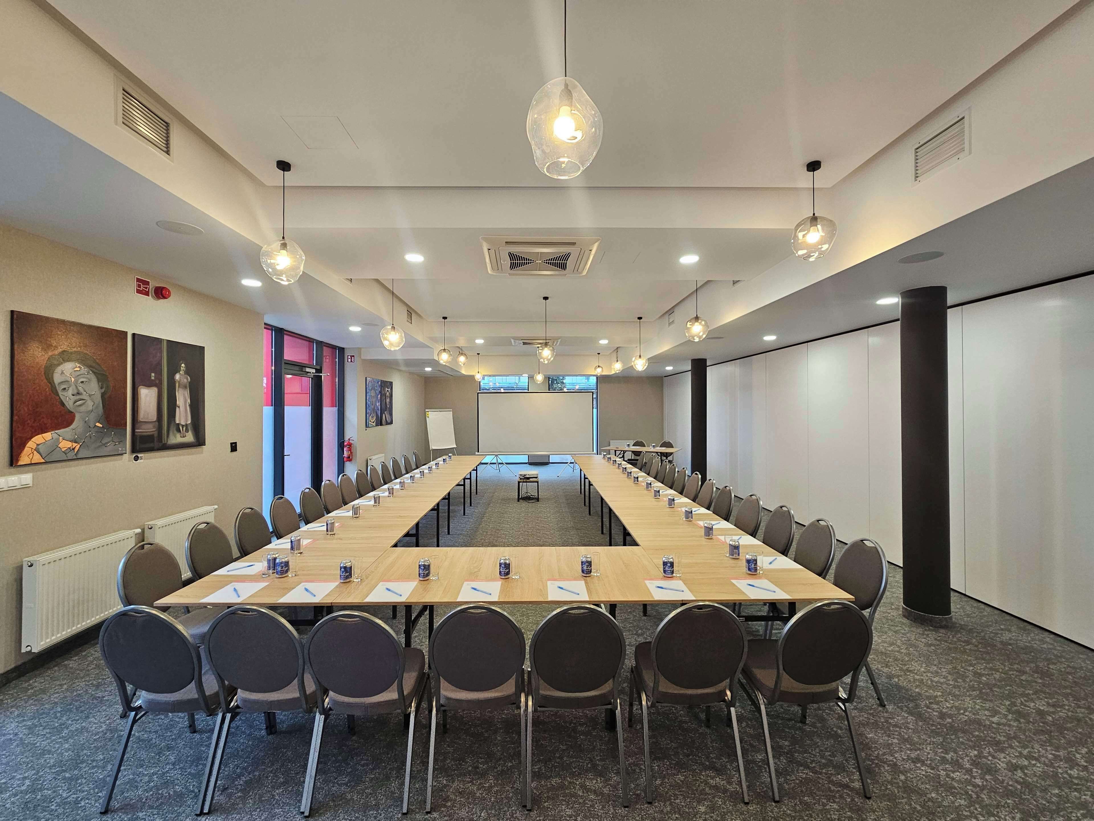 A conference room with a long table, chairs, and a whiteboard.