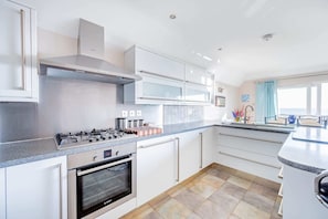 Enjoy cooking in this well-lit kitchen with a gas stove, oven, and ample counter space.