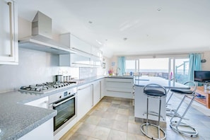 Enjoy meals in the kitchen with a large island and bar stools, offering ample counter space and a view of the city skyline.