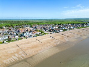 Un pueblo costero con una playa de arena y casas a lo largo de la costa.