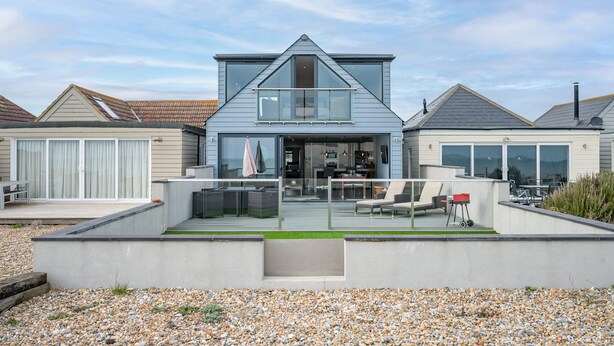 A modern two-story house with a balcony, a garage, and a well-maintained garden. - Beach View Breeze (Pevensey)