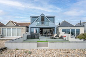 A modern two-story house with a balcony, a garage, and a well-maintained garden. - Beach View Breeze (Pevensey)