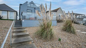 A residential area with houses, a staircase, and a small garden with pampas grass. - Beach View Breeze (Pevensey)