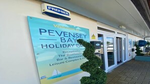 A sign welcoming visitors to Penzey Bay Holiday Park, indicating the presence of a reception, The Boathouse, Bar & Restaurant, and Leisure Complex. - 27 Tower View Pevensey Bay Holiday Park Beach (Pevensey)