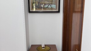 A hallway with a framed landscape painting, a wooden cabinet with drawers, and a wooden door. - Montefortino Sibillini House B&B (Montefortino)