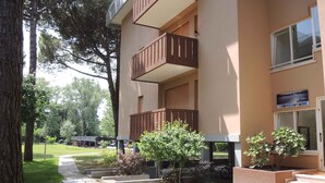 Un edificio de dos pisos, con un cartel que dice 'Residence Corinzia' y un camino pavimentado que lleva a la entrada.