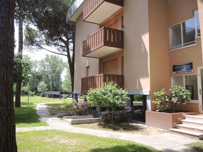 A building with a two-story structure, a sign indicating 'Residence Corinzia,' and a paved pathway leading to the entrance.