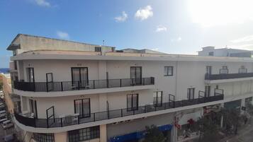 A multi-story building with balconies, large windows, and a flat roof.