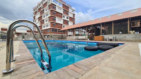 Relax by the rooftop pool with a stunning view of the hotel building.