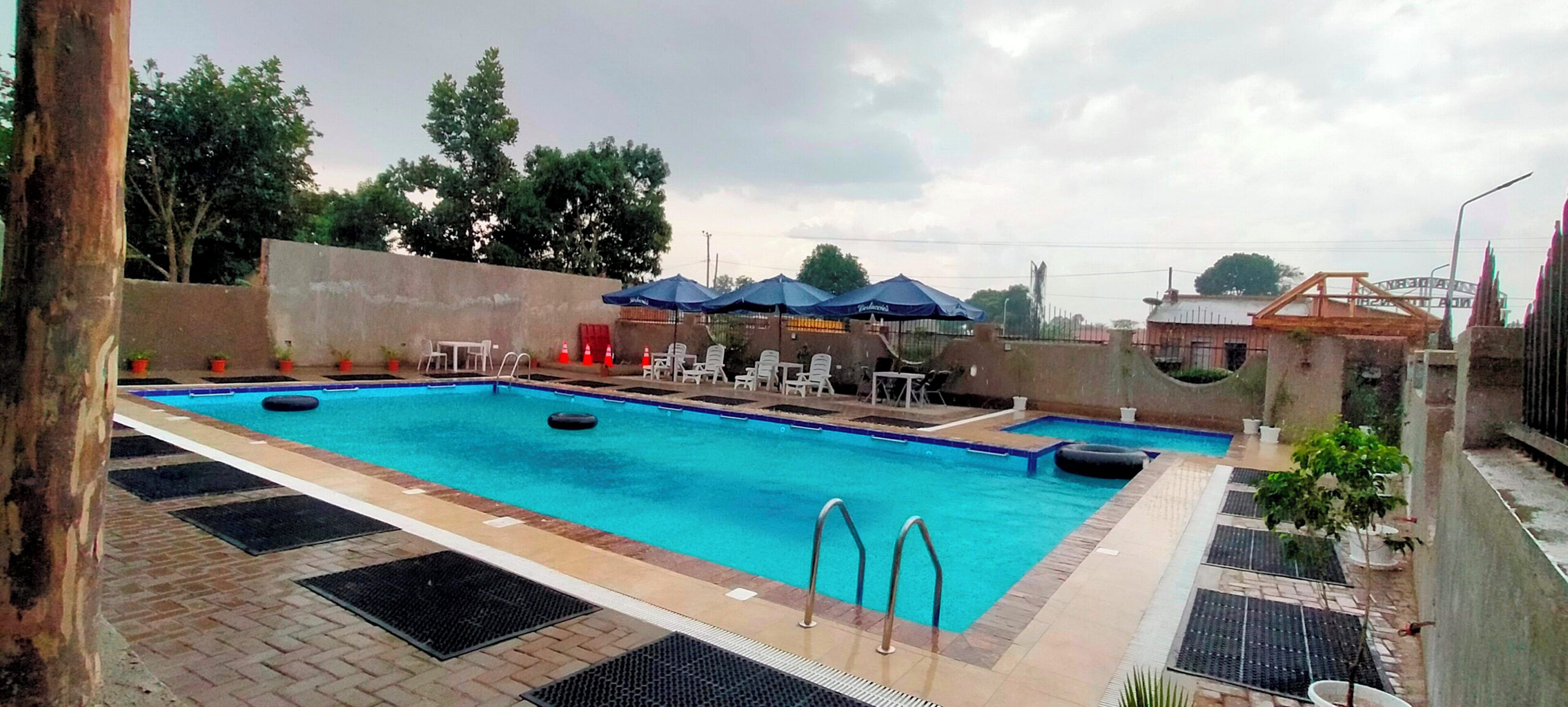 A swimming pool with two lanes, lounge chairs, and umbrellas.