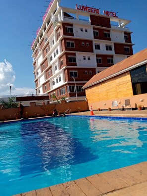 Experience the Luweer Hotel's inviting pool area, featuring a diving board and lifeguard stand.