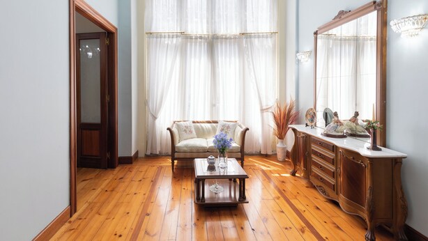 A room with a wooden floor, a sofa, a coffee table, a cabinet, and a large mirror. - Jauregi - baskeyrentals (Lekeitio)