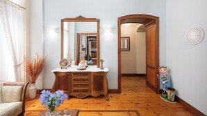 A room with a wooden dresser, a mirror, a vase with flowers, and a figurine. - Jauregi - baskeyrentals (Lekeitio)