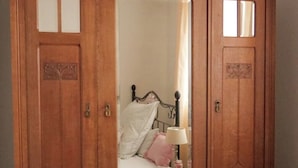 Ein Holzschrank mit Spiegel, Schubladen und einem kleinen Hocker im Inneren.