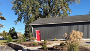 A building with a red door marked with the number 48, surrounded by landscaped garden beds and a paved driveway. -  Explorer Rest & Recreation (Sandusky)