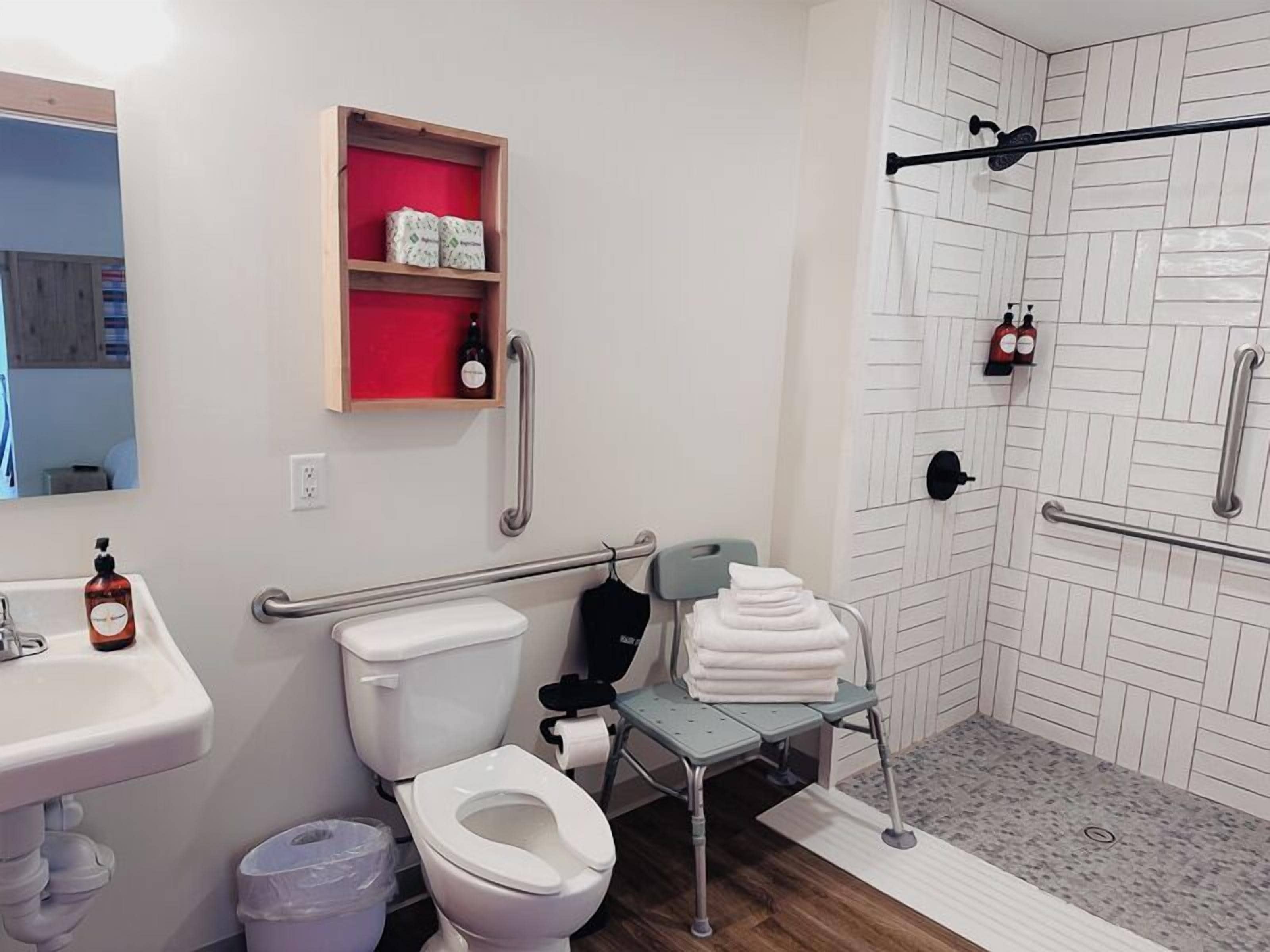 A modern bathroom with a toilet, sink, and shower area.