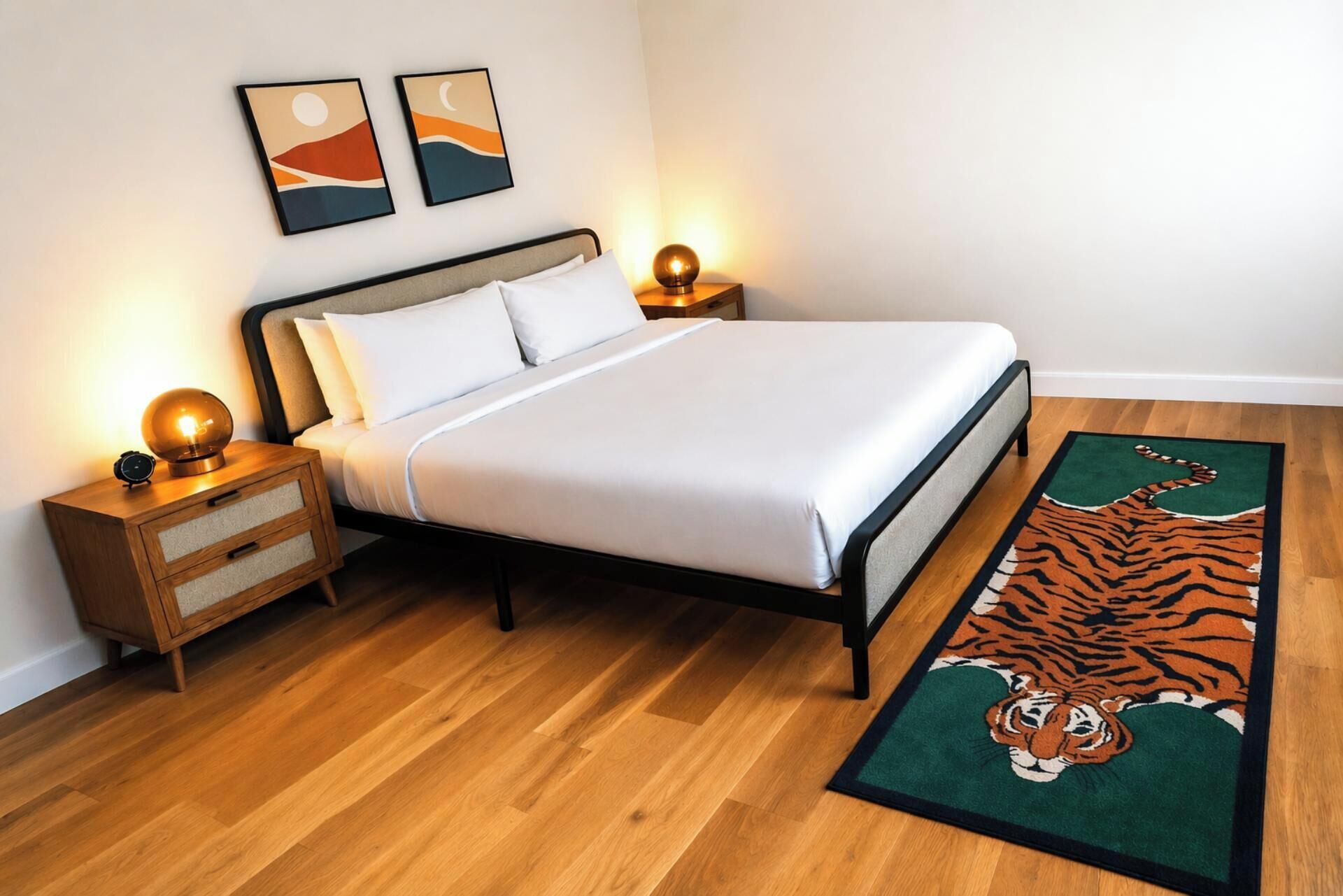 A neatly arranged bedroom with a bed, bedside tables, and a tiger-themed rug.