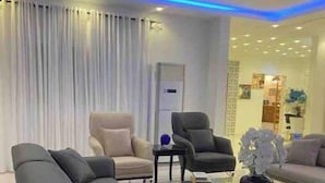 Ein modernes Wohnzimmer mit einer Sofagarnitur, einem Couchtisch und einer dekorativen Vase.