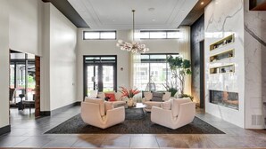 Un vestíbulo moderno con zona de estar, ventanas amplias y una lámpara decorativa.