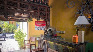 Una zona de bar con mostrador de madera, sillas y una lámpara decorativa.