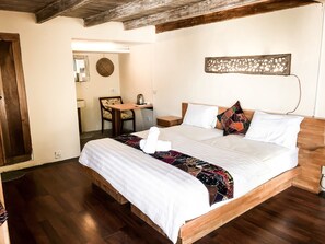 A neatly arranged bedroom with a wooden bed, a small desk, and a chair. - Tree House Lodge (Nusa Dua)