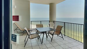 Een balkon met een tafel en stoelen, uitzicht op zee, en een bordje dat aangeeft dat het balkon gesloten is.