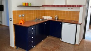 Una cucina compatta con lavello, bollitore e lavastoviglie.