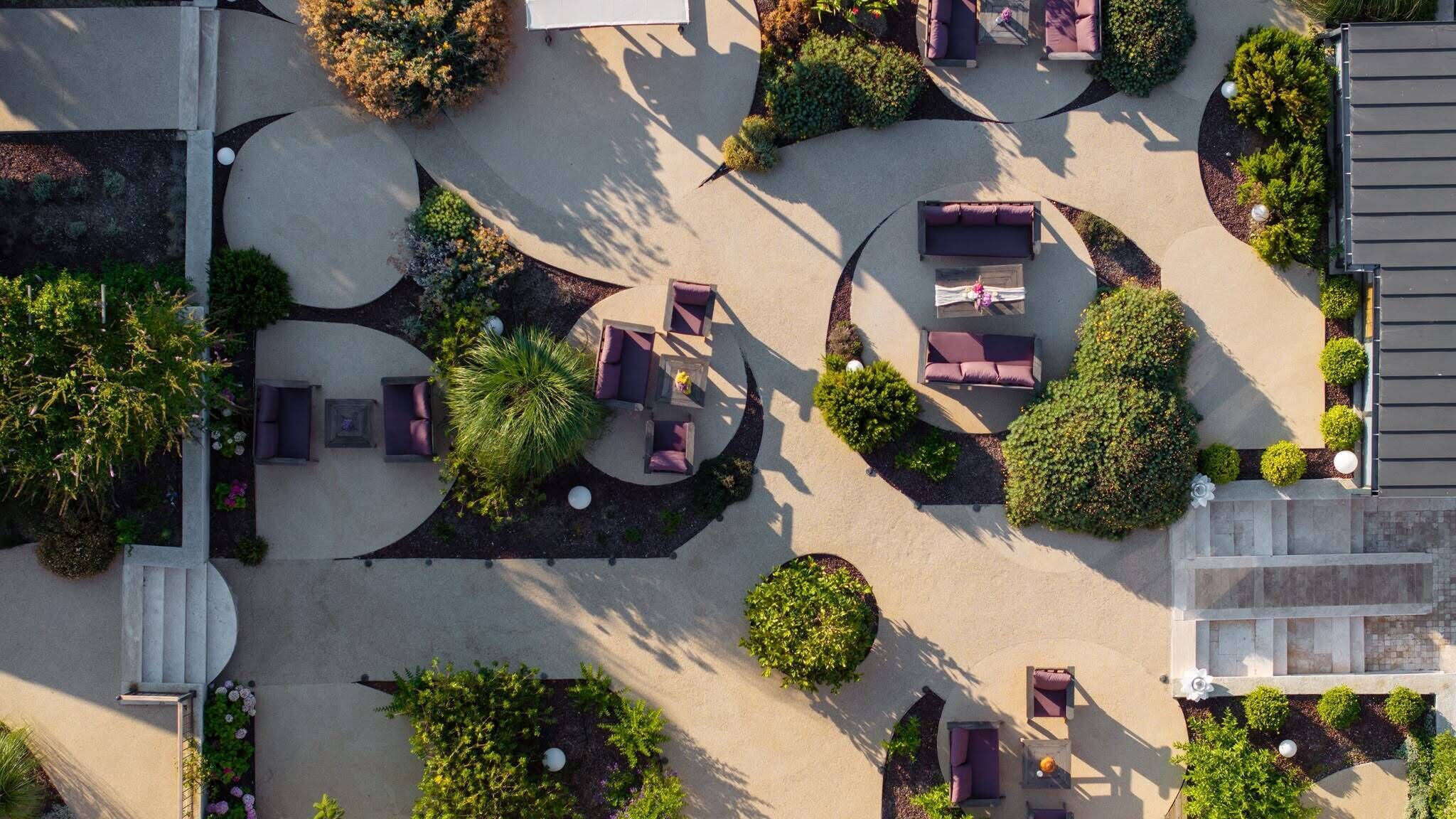 An aerial view of a landscaped outdoor area with multiple seating arrangements and pathways.