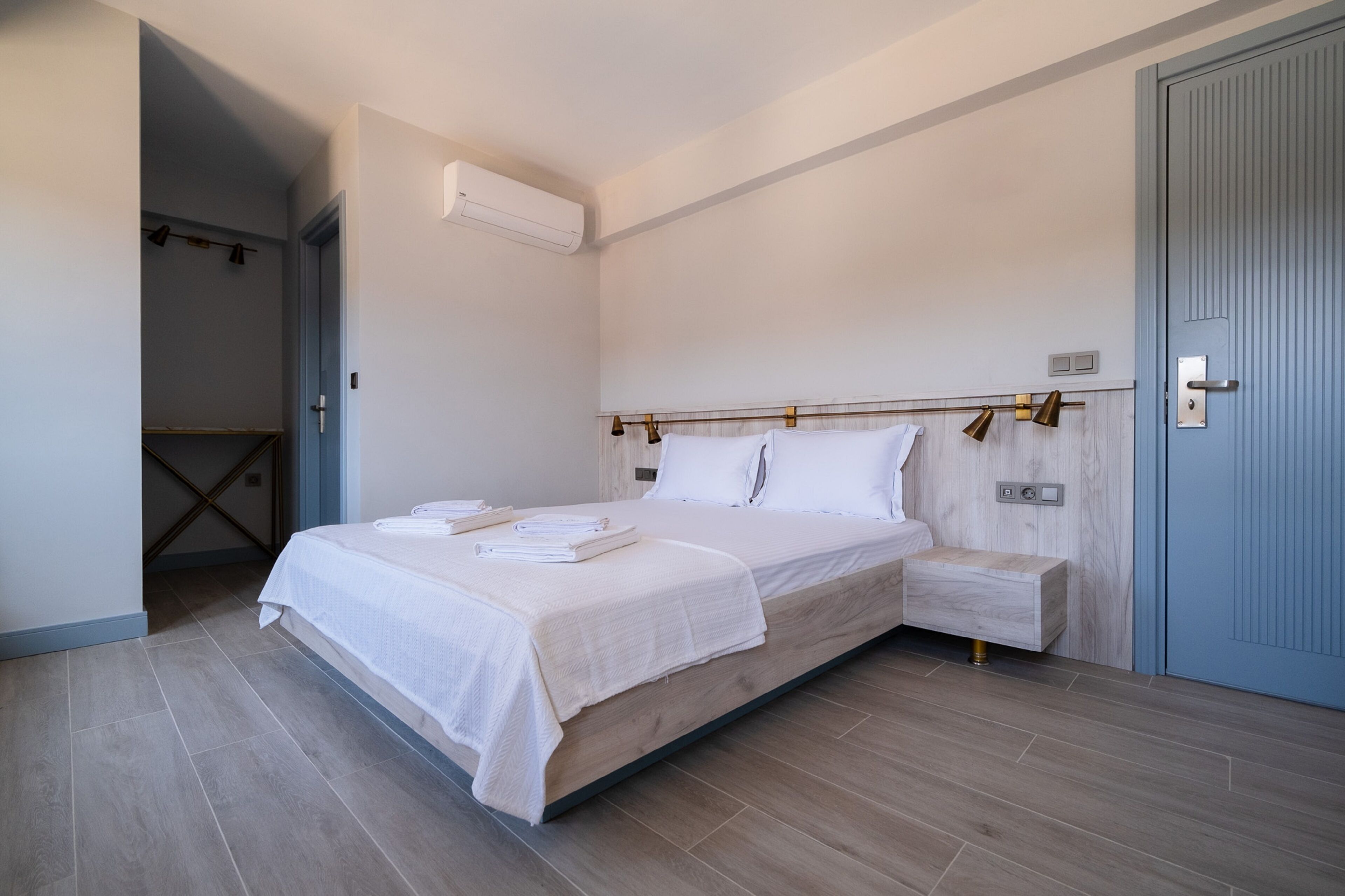 A modern bedroom with a bed, bedside table, and a wardrobe.