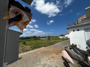 Guests can park their vehicles on the paved driveway, with a scooter available for use.