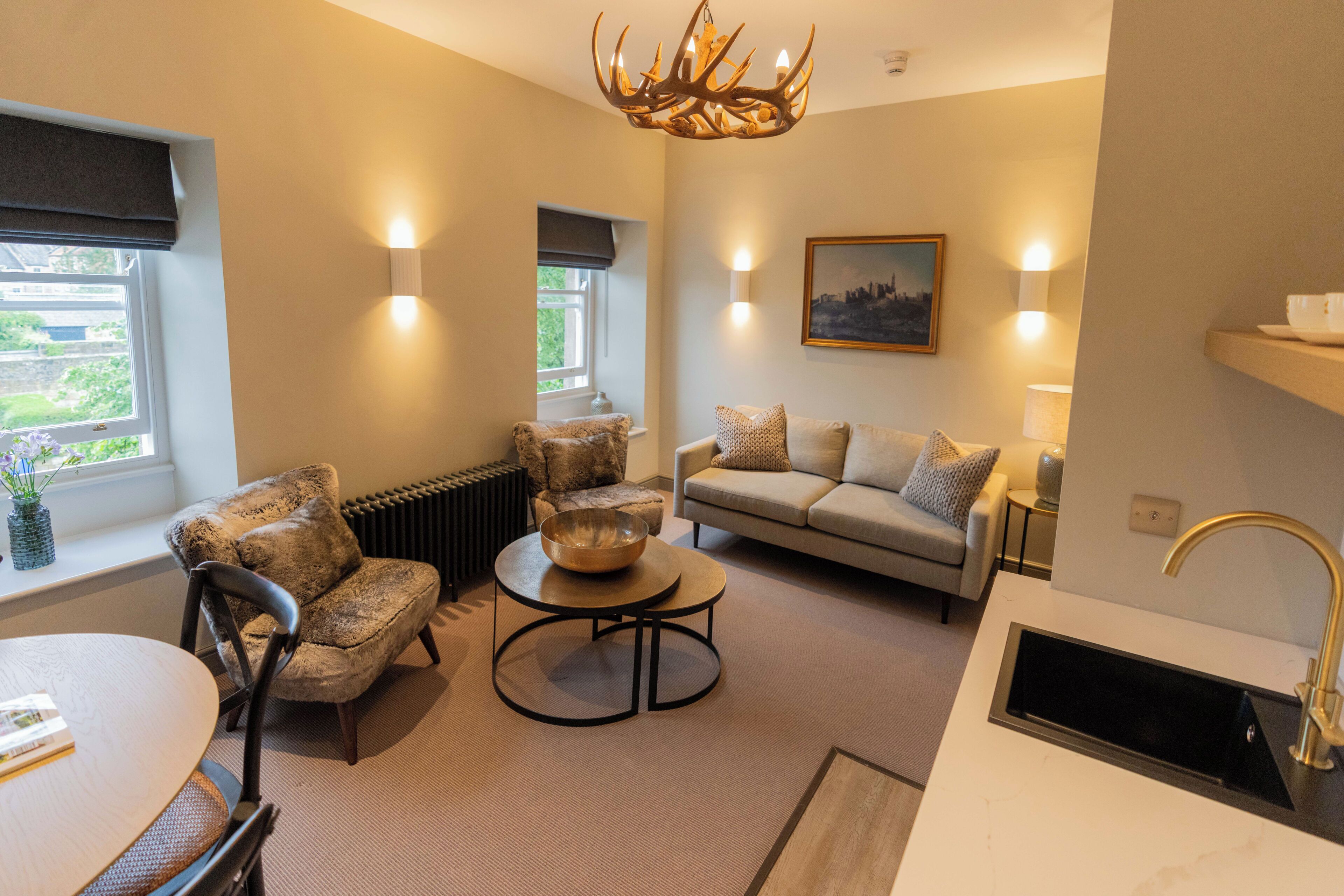 A living room with a sofa, armchairs, a coffee table, and a fireplace.