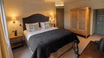 Une chambre d’hôtel avec un grand lit, des lampes de chevet, une armoire et un bureau.