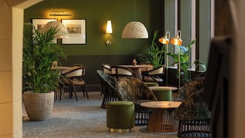 A modern lounge area with a round table, comfortable seating, and ambient lighting.