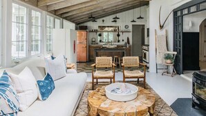 Un vaste espace de vie comprenant un canapé, des fauteuils, une table basse et une cheminée.