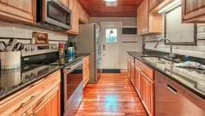 A kitchen with wooden cabinets, stainless steel appliances, and a tiled backsplash.