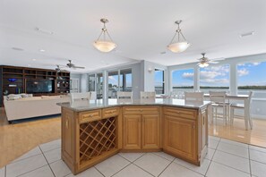 Cozinha moderna com adega, área de jantar com cadeiras e uma janela grande que oferece uma vista.