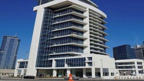 Um hotel moderno de vários andares com fachada curva, grandes janelas de vidro e um letreiro 