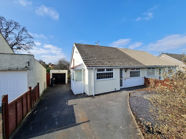 A residential property with a garage, a covered driveway, and a white exterior.