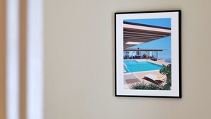 Ein gerahmtes Kunstwerk, das ein modernes Gebäude mit Pool und Lounge zeigt.