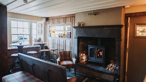 Una habitación acogedora con chimenea, muebles de madera y ventana con vistas.
