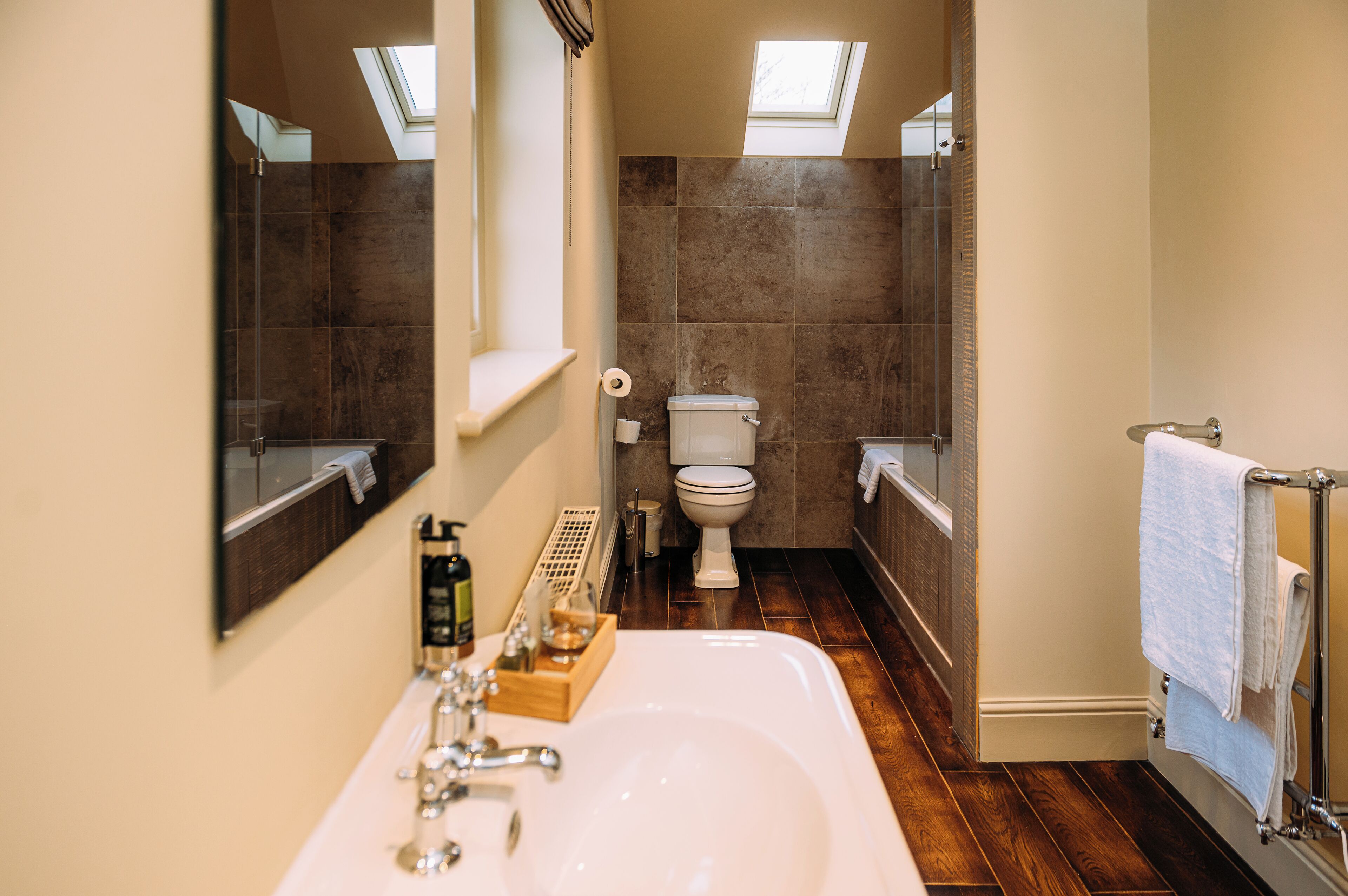 A bathroom with a large sink, a toilet, and a shower area.