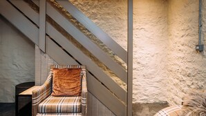 Un interior moderno con una escalera, un sofá estampado de pata de gallo y una pared con textura.