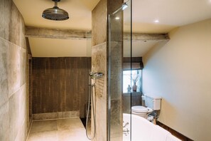 Un baño moderno con ducha envuelta en vidrio, inodoro y bañera.