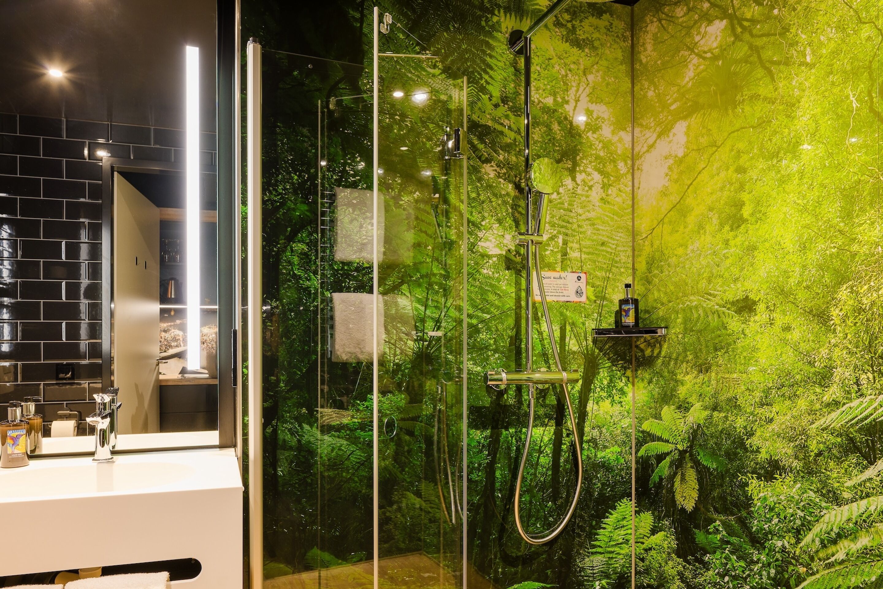 A modern bathroom with a glass-enclosed shower, a white sink, and a mirror.