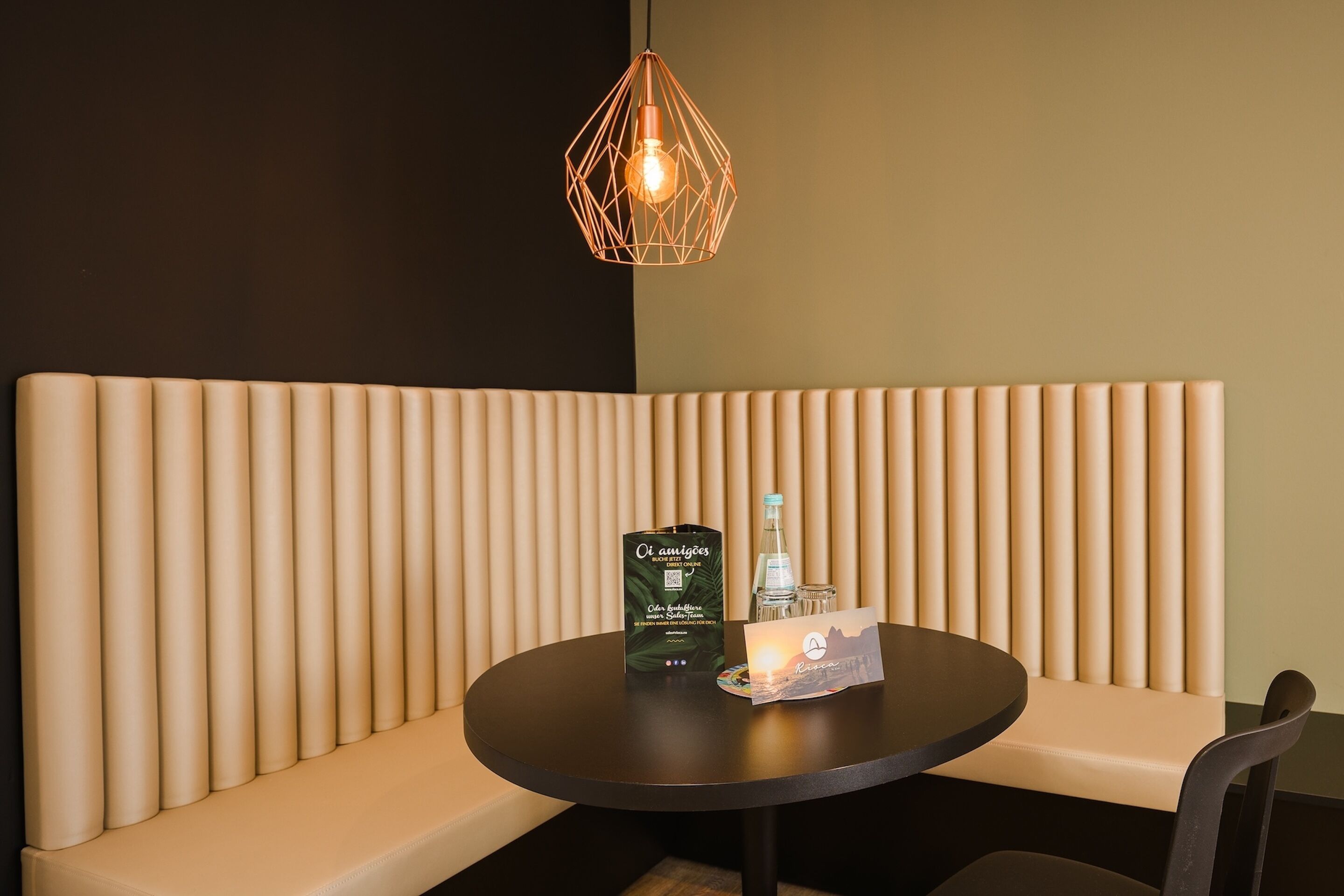 A seating area with a round table, a bottle, and a menu.