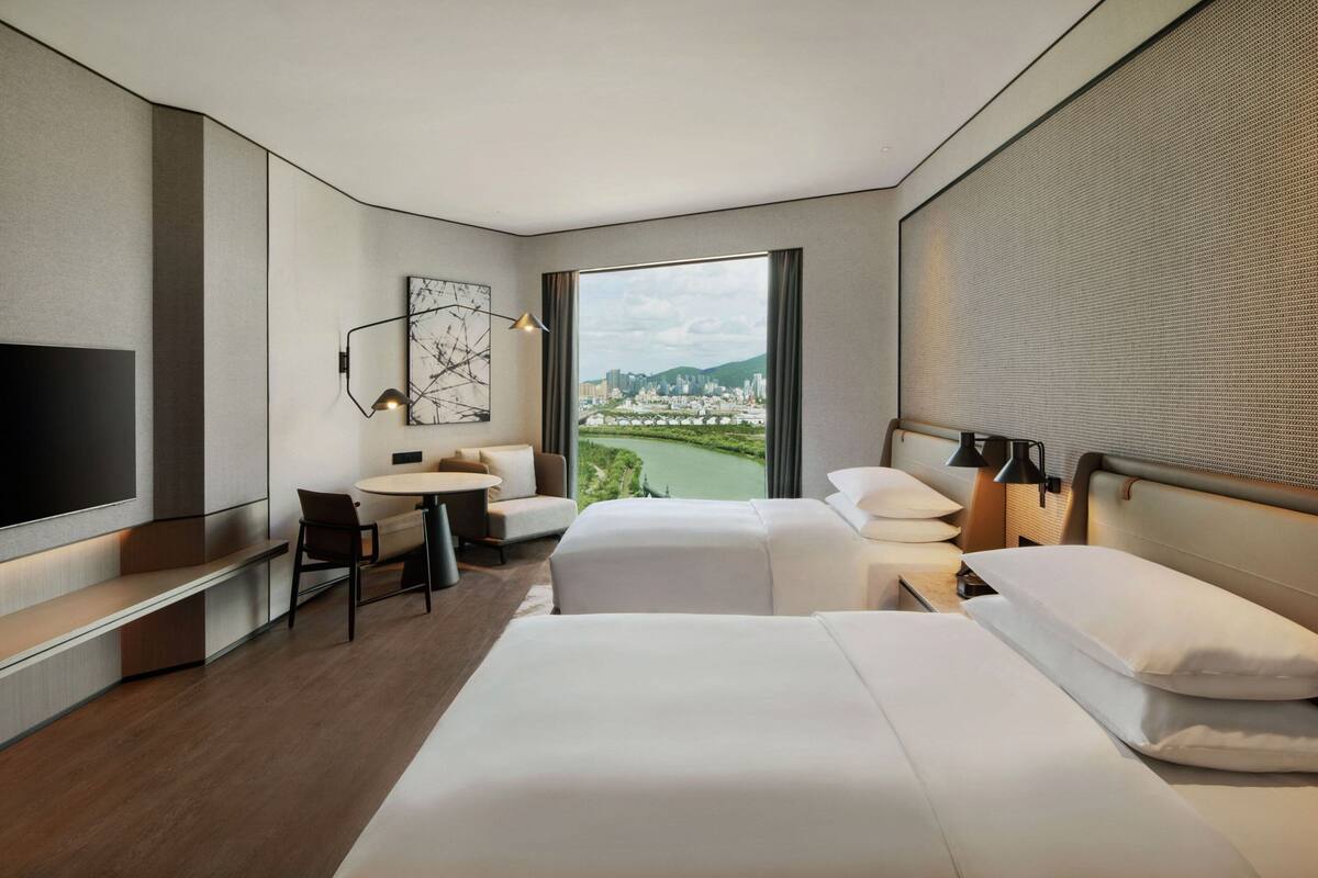 Une chambre d’hôtel moderne équipée d’un grand lit, d’un bureau, d’une chaise et d’une télévision.