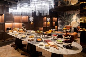 A well-lit buffet with various food items and a chandelier. - Orient Occident Hotel Istanbul, Autograph Collection (Istanbul)