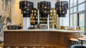 A bar area with a wooden counter, multiple hanging black chandeliers, and a view of the outside through large windows. - Orient Occident Hotel Istanbul, Autograph Collection (Istanbul)