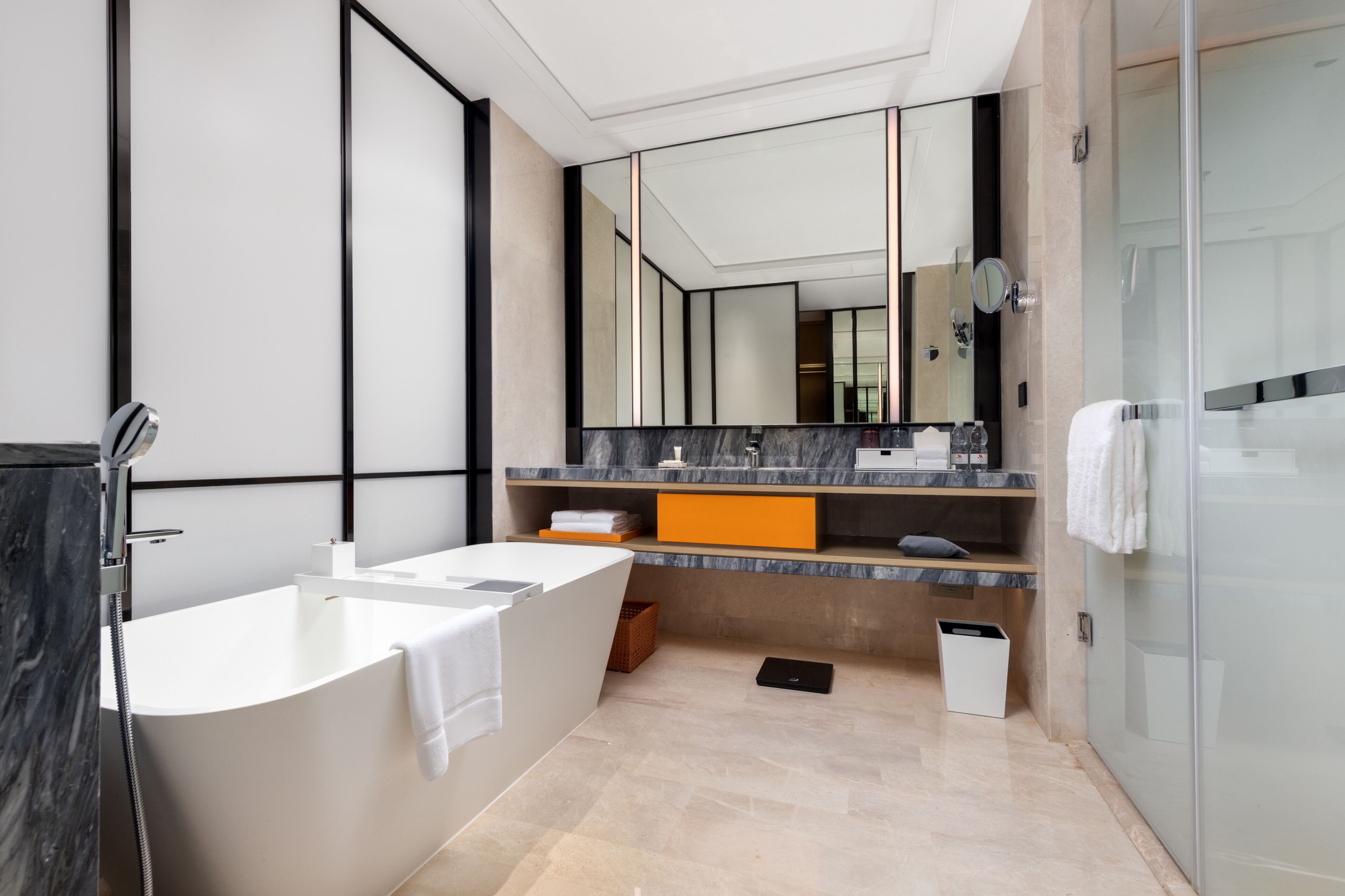 A modern bathroom with a freestanding bathtub, a large mirror, and a glass shower enclosure.